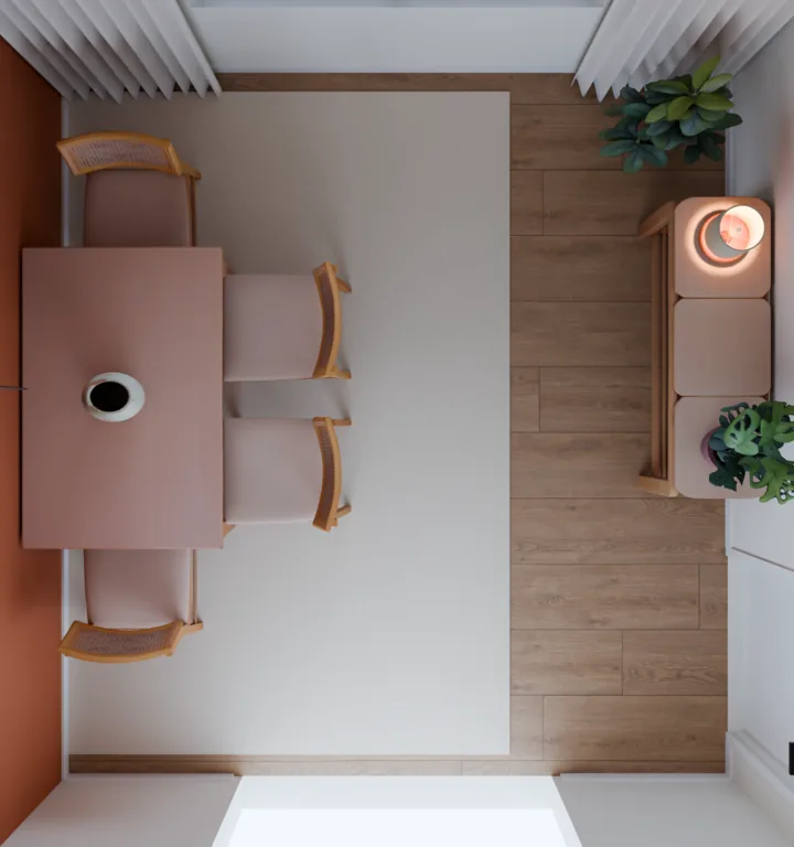Planta vista de cima de uma sala de jantar: mesa de madeira encostada na parede terracota com quatro cadeiras sobre um tapete claro e, na parede em frente, um aparador de madeira com luminária e plantas