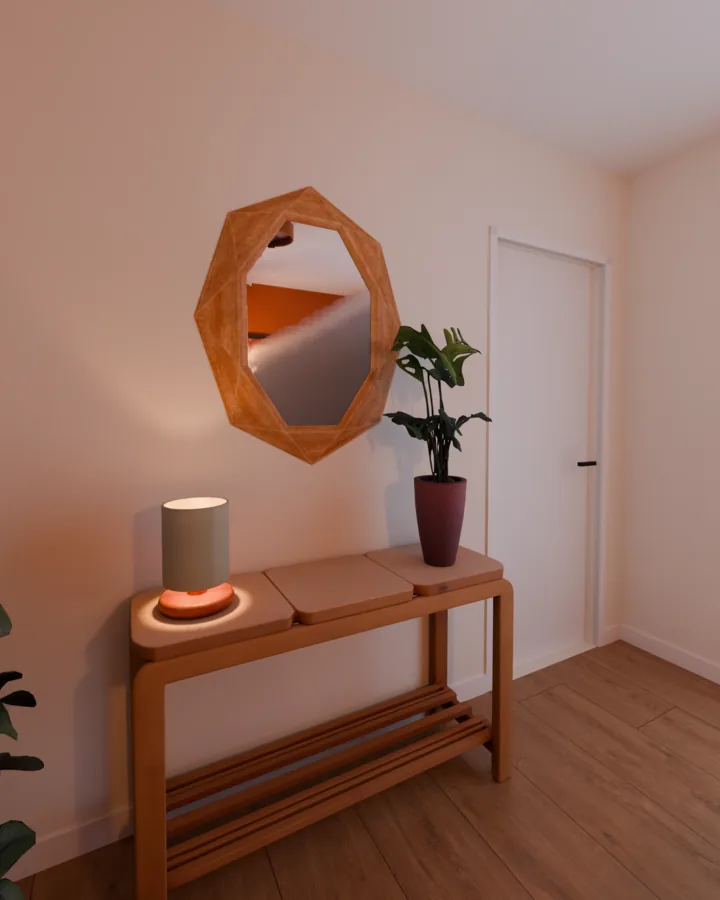 Aparador de madeira com luminária de mesa acesa e planta, espelho de moldura de madeira facetada acima dele refletindo a parede terracota, porta branca ao lado
